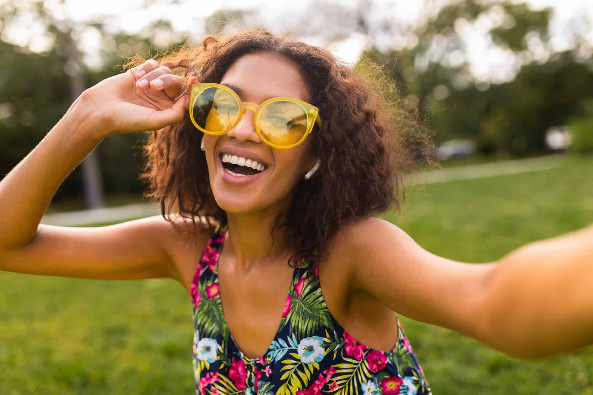 young stylish black woman having fun in park summer fashion style